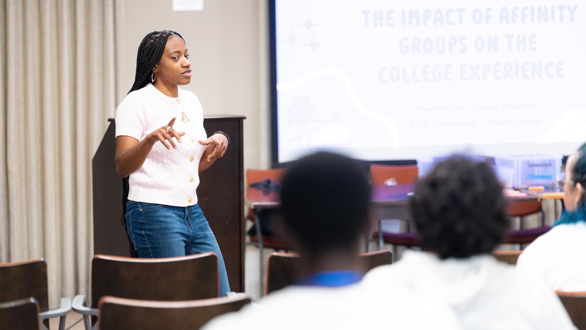 A staff member talks to students