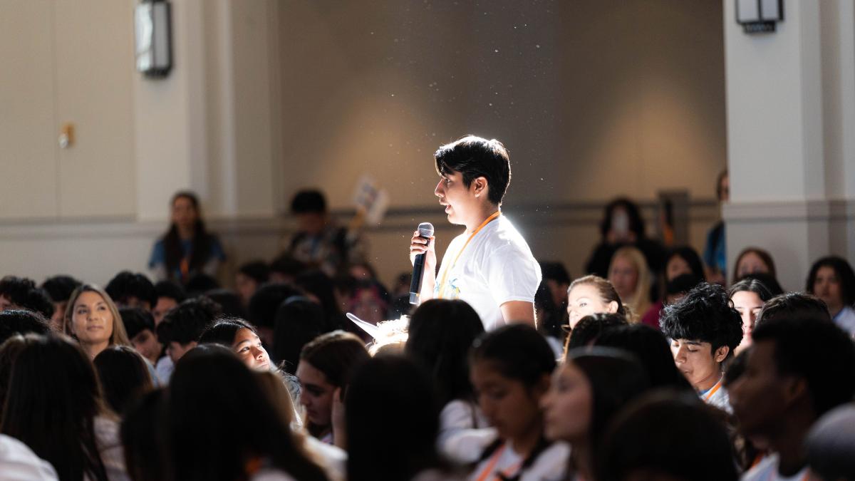 A student asks a question in a ballroom