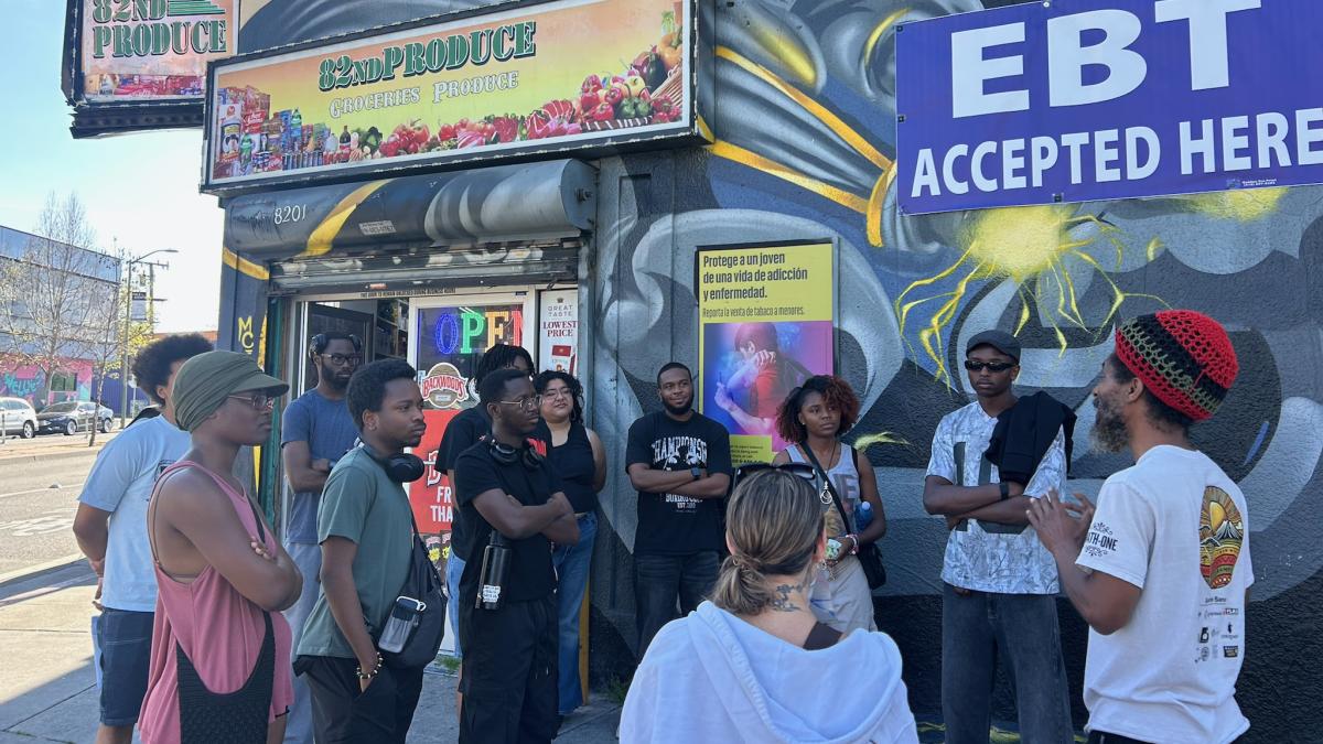 Students listen outside a store