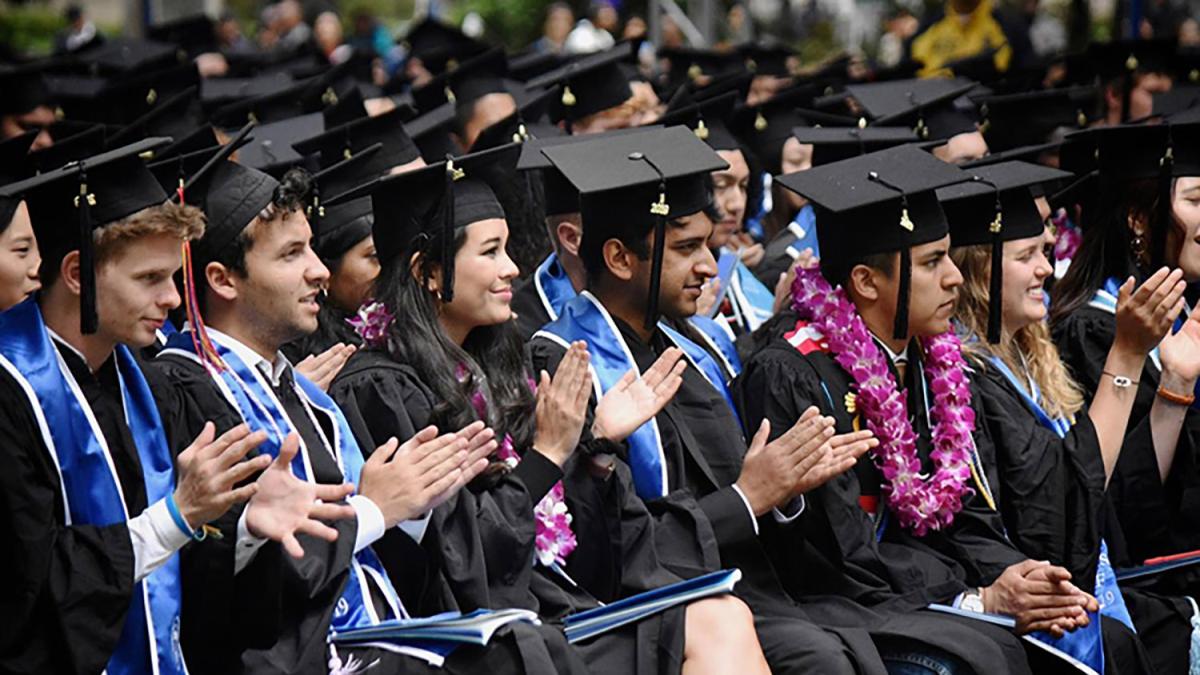 Graduating students clapping during commencement ceremony