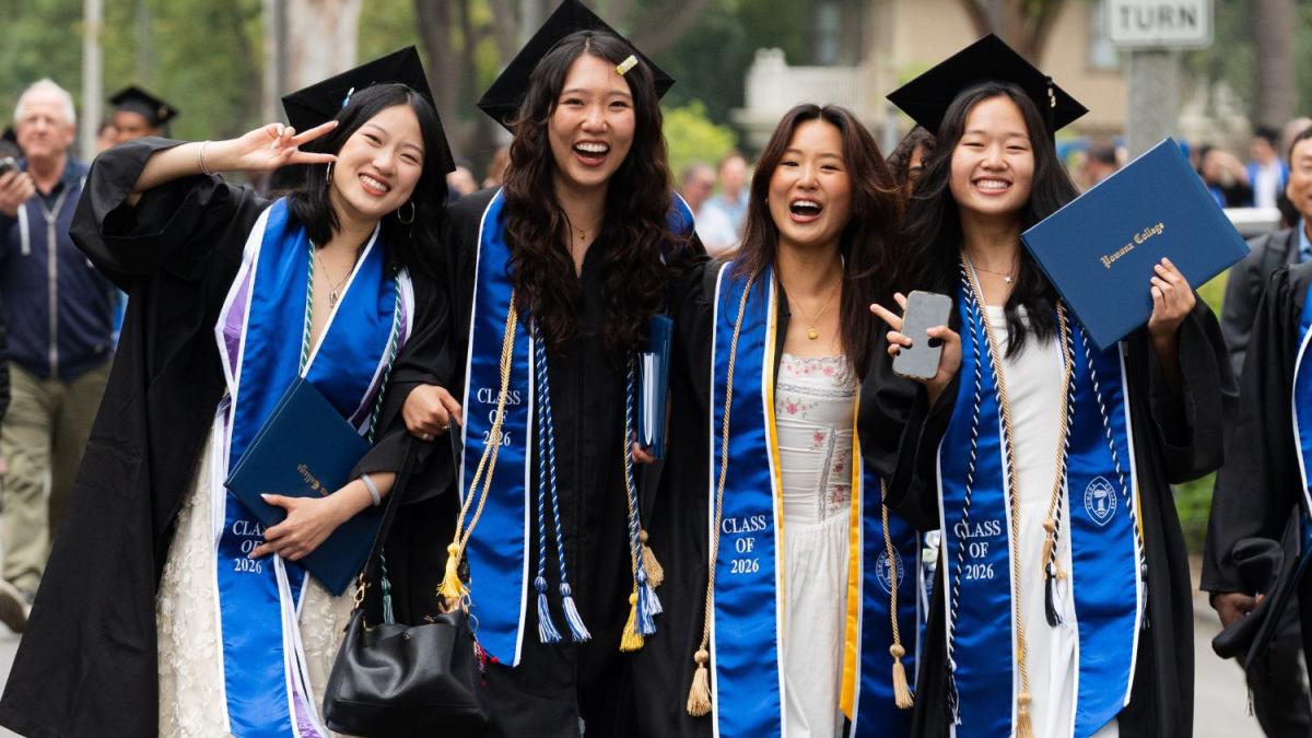 four graduates walking the class parade at commencement