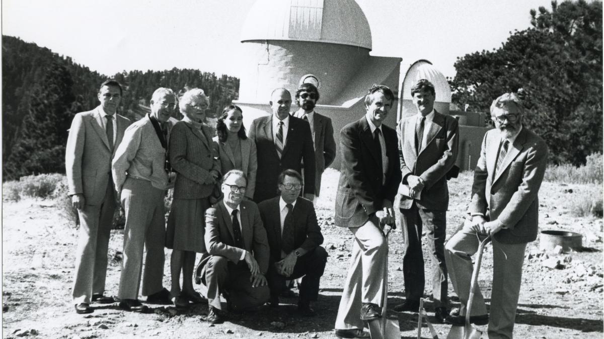 Men with shovels in front of a telescope