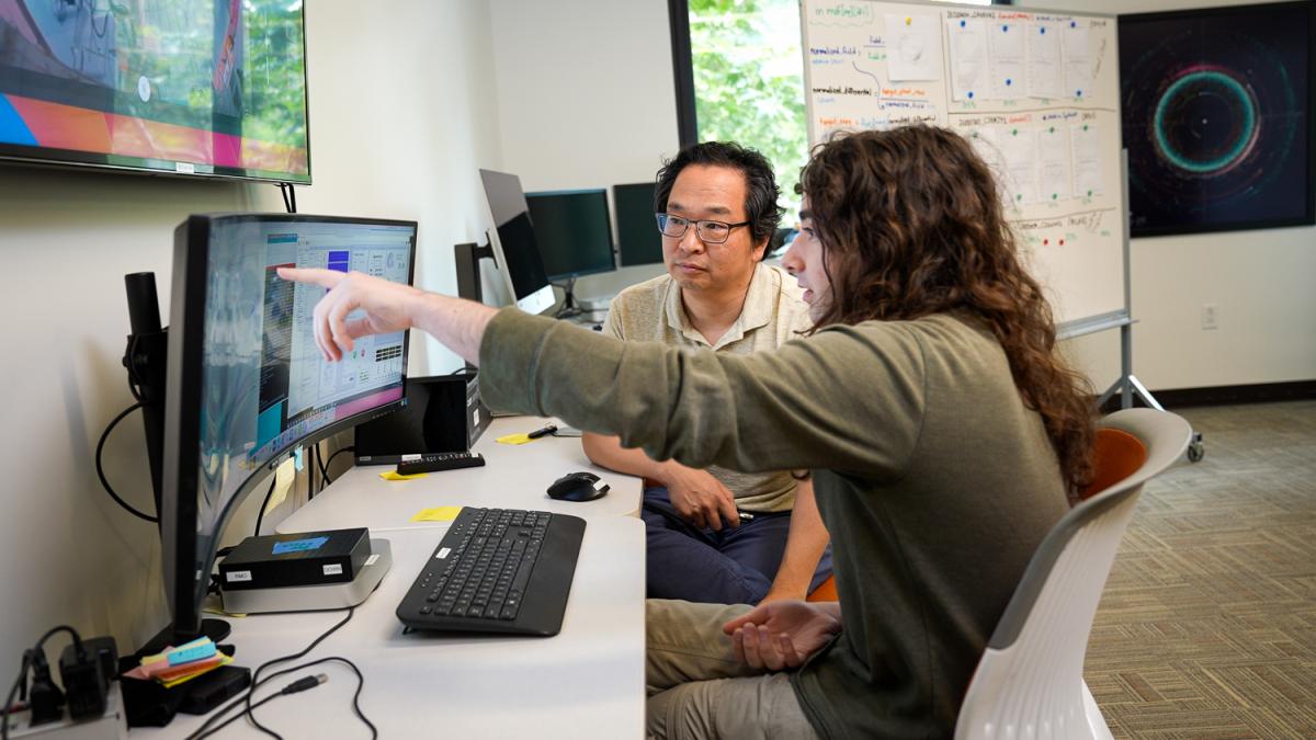 A student points at a computer screen