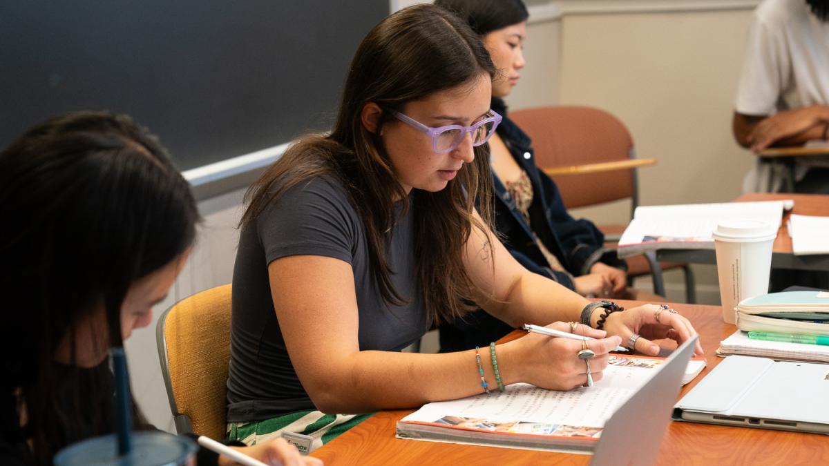 A student writes in a notebook