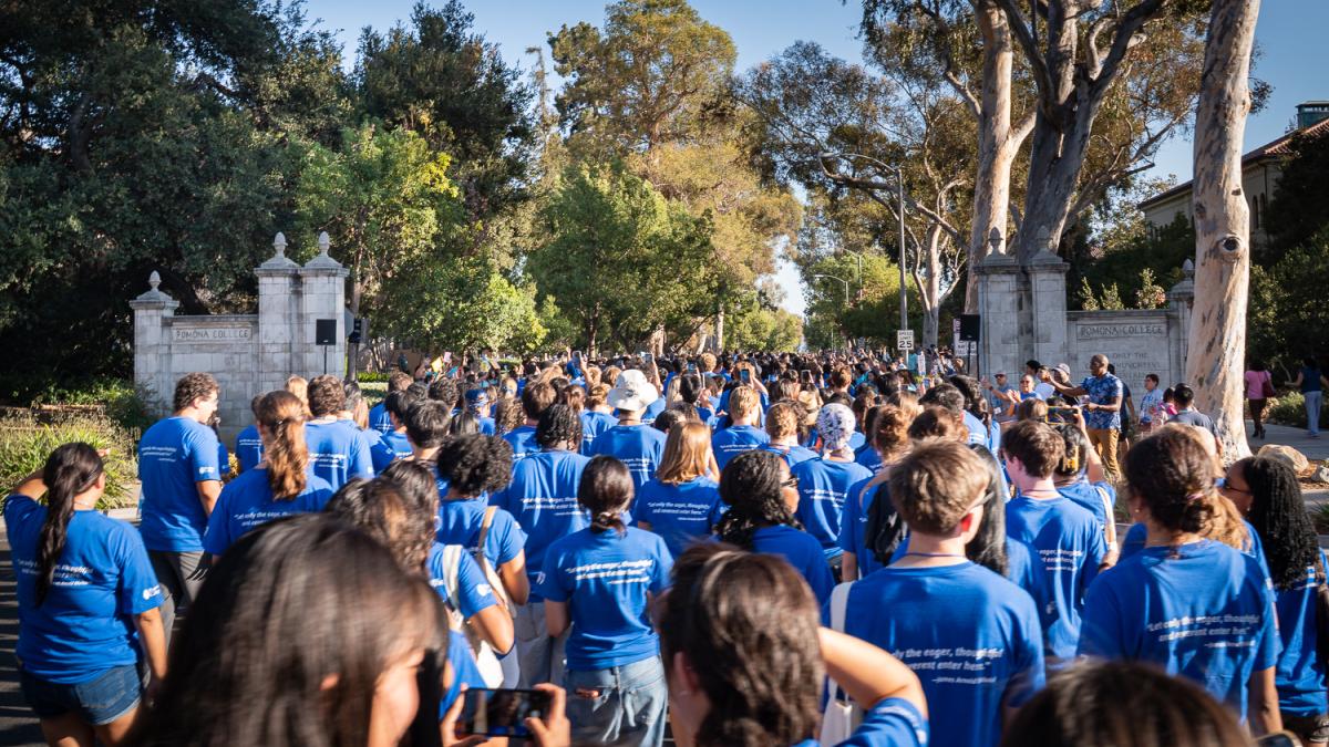 Dozens of students walk down a street