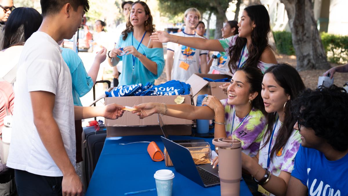 Students hand another student a card