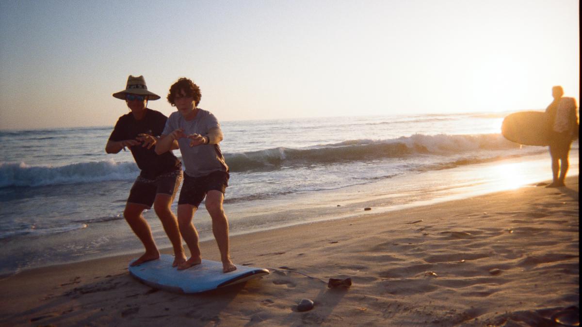 Two boys on a surfboard