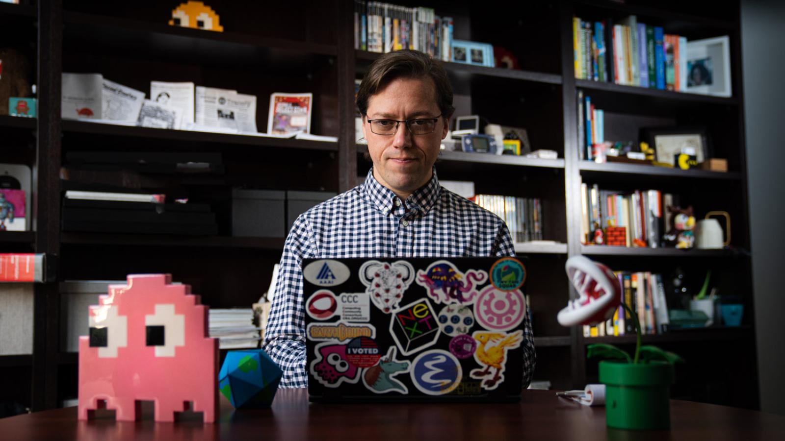 Prof. Joseph Osborne works on his laptop in his office.