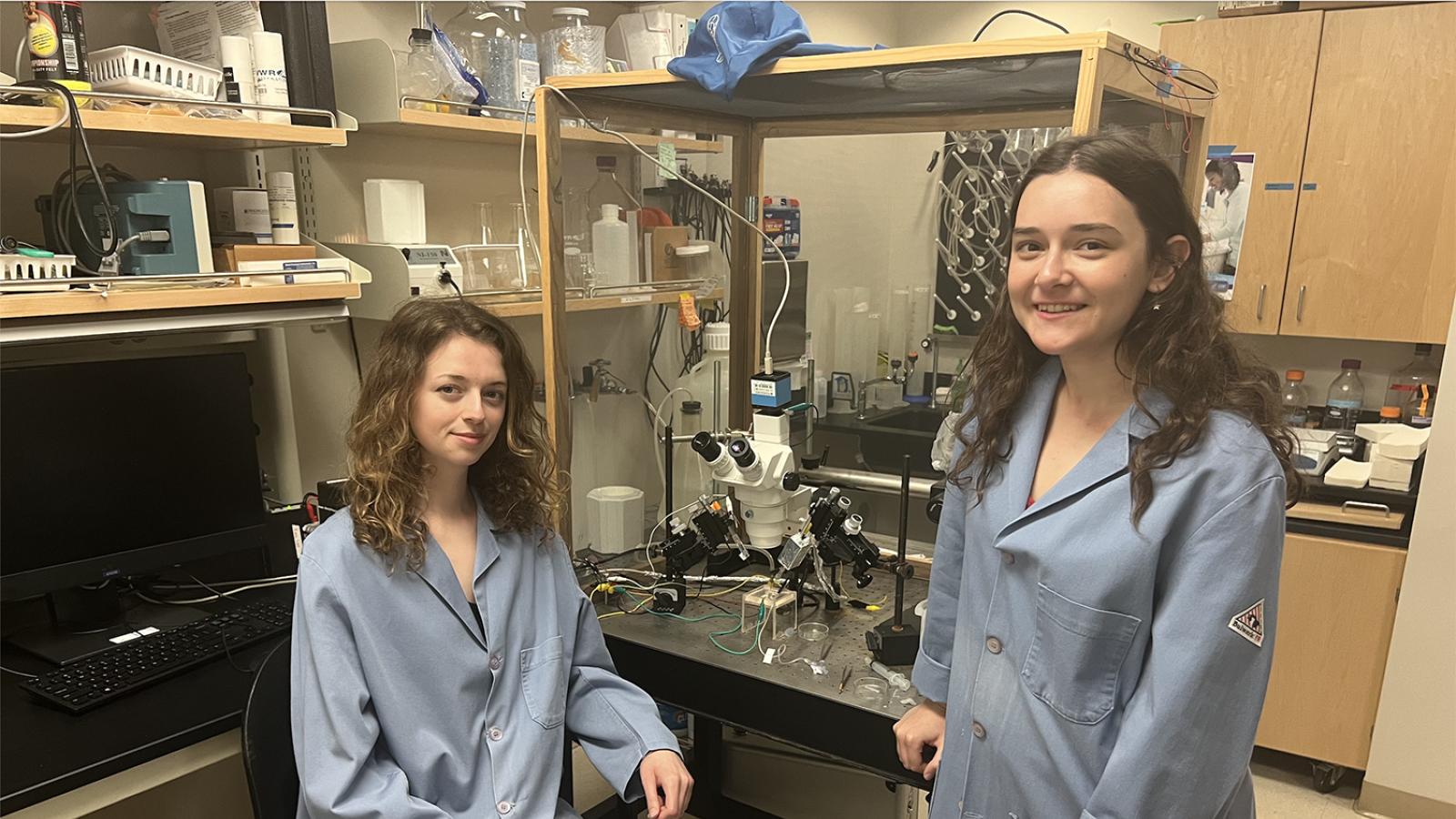 Two students pose in lab