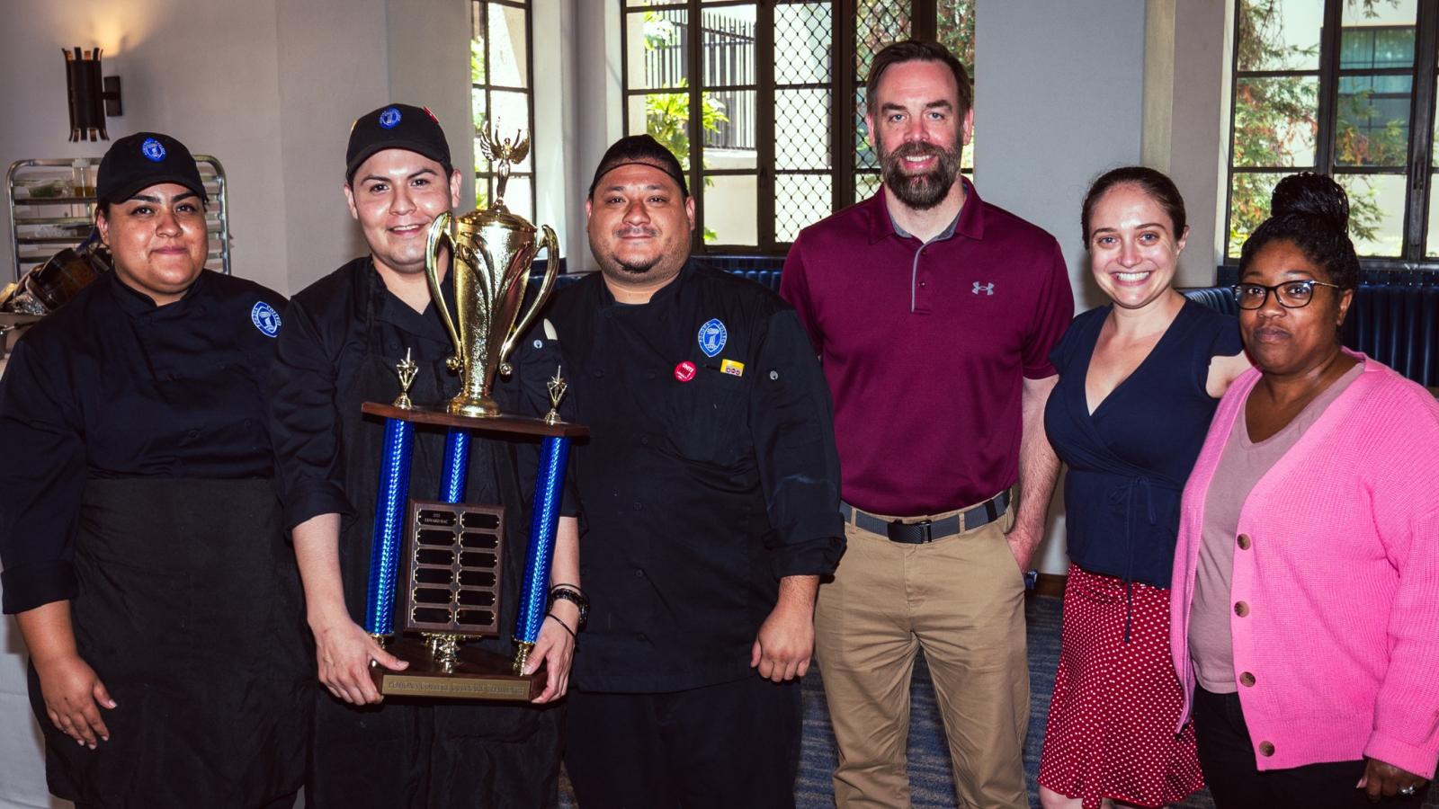 Eric Bautista poses with trophy in dining hall 