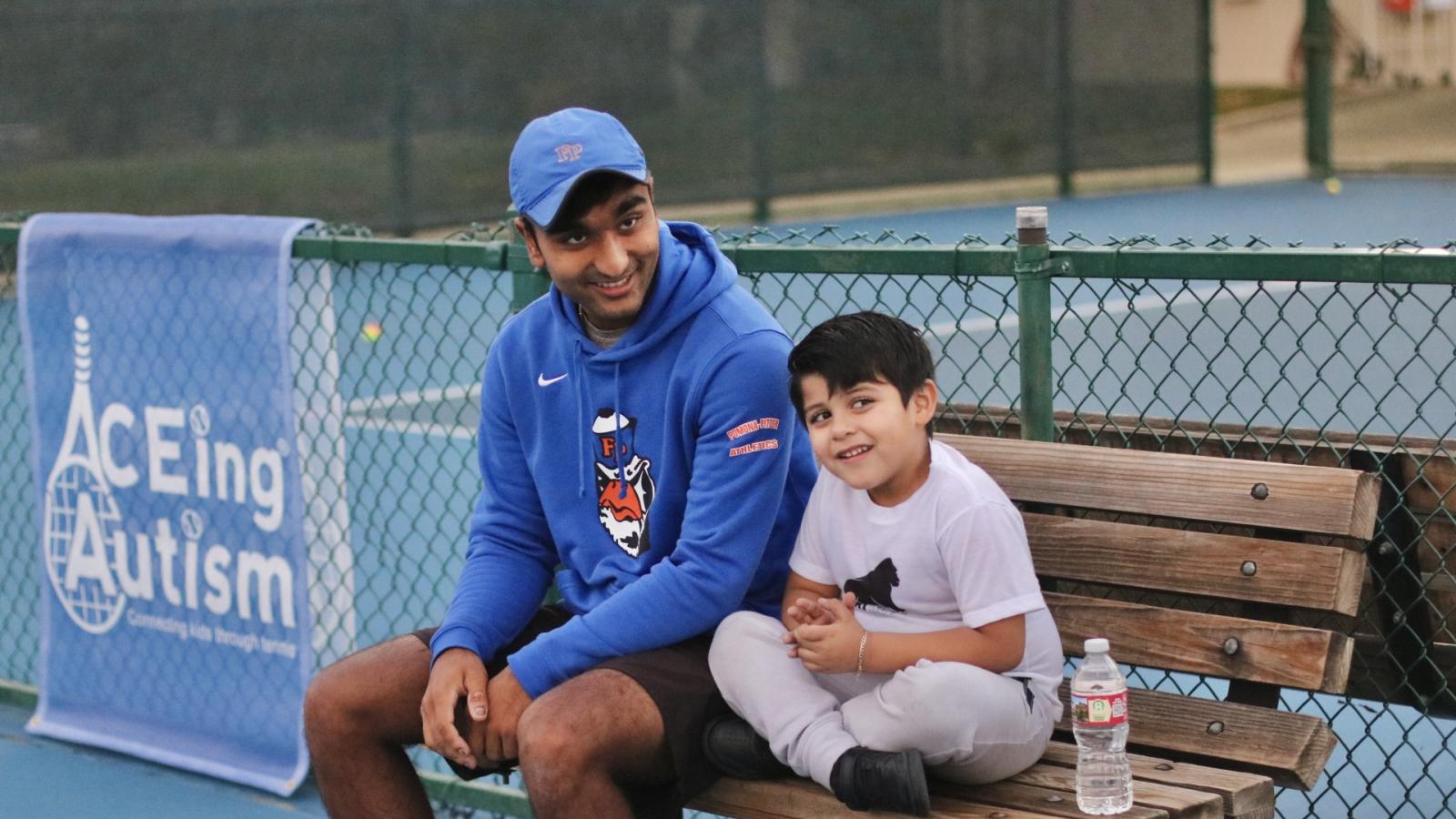 Sagehen tennis player with child during ACEing Autism session at Pomona College.