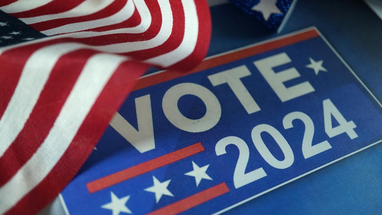 Image of U.S. flag and sign reading Vote 2024