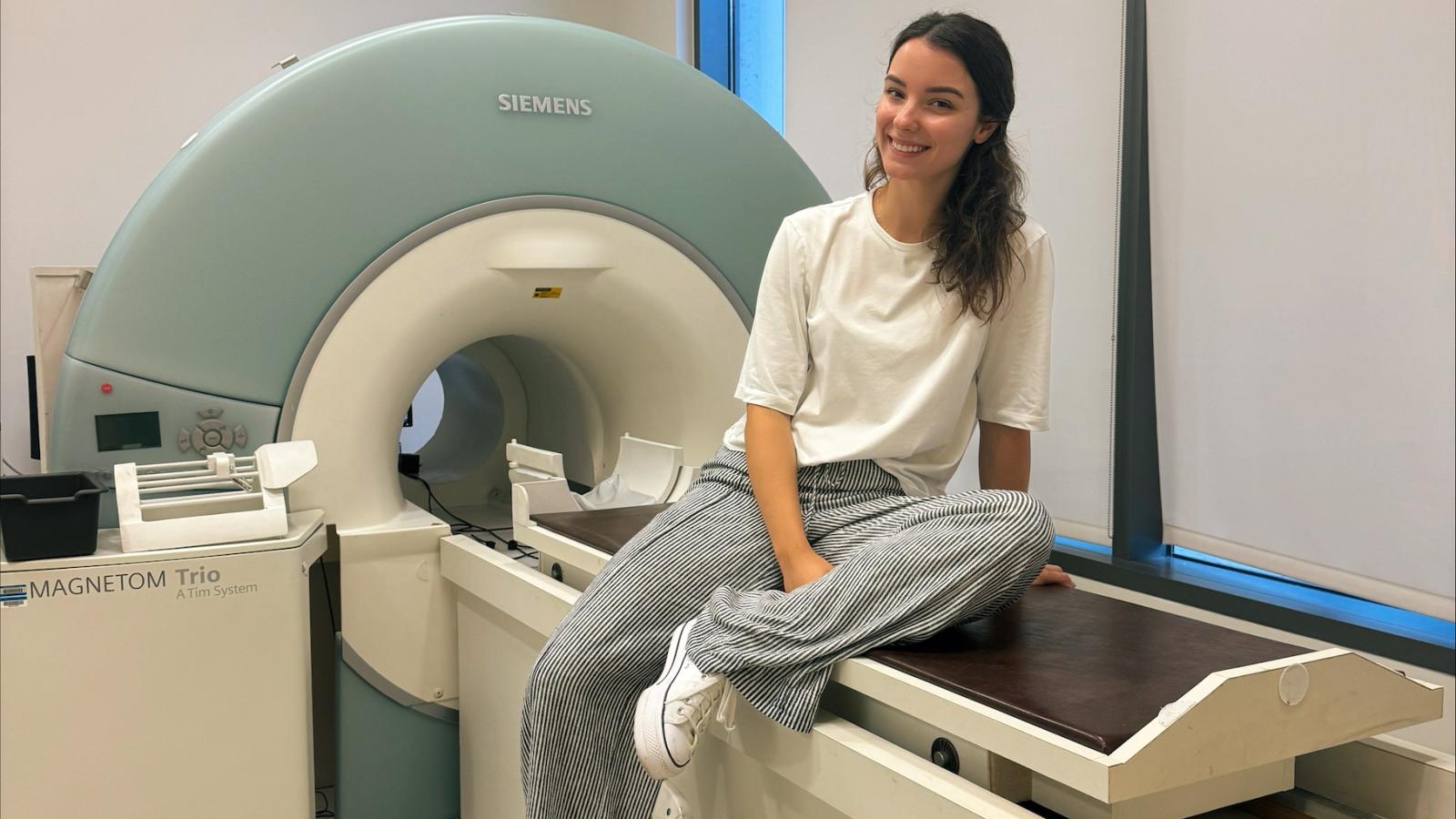 Aiste Abeciunaite seated on fMRI machine in imaging center