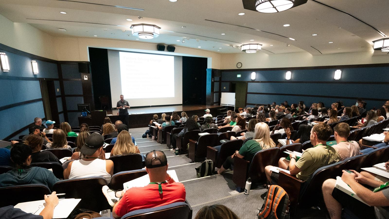 A professors stands in front of a group of students