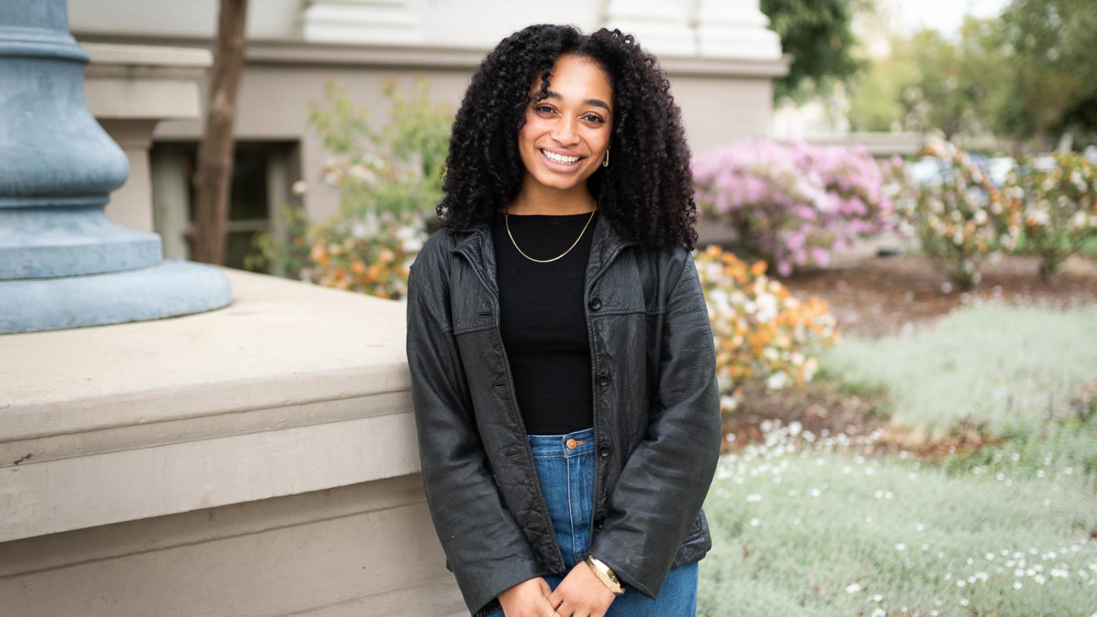 Nadiya Muhammad '25 standing in front of Carnegie building on Pomona College campus.