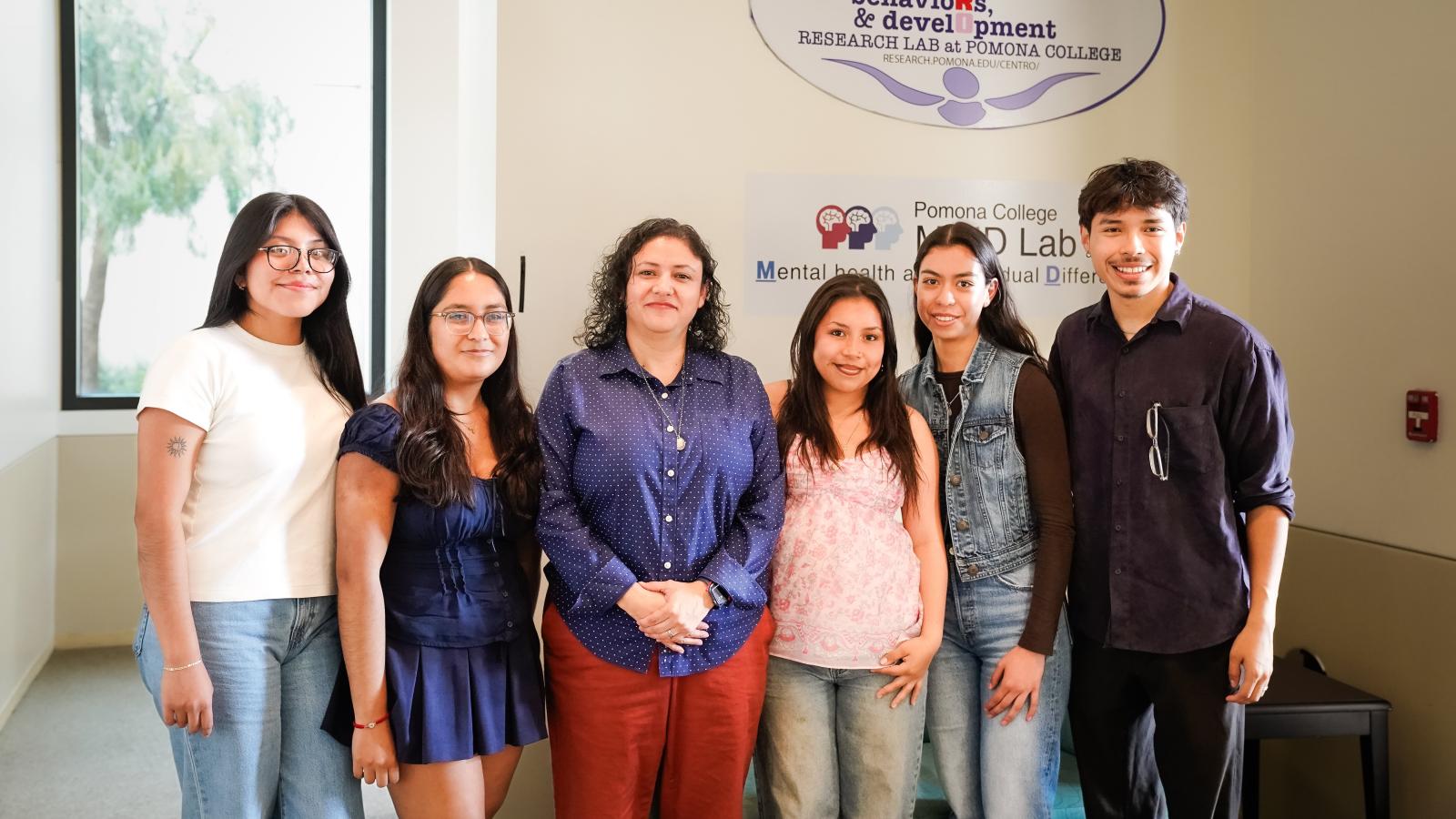 Students flank a professor for a photo