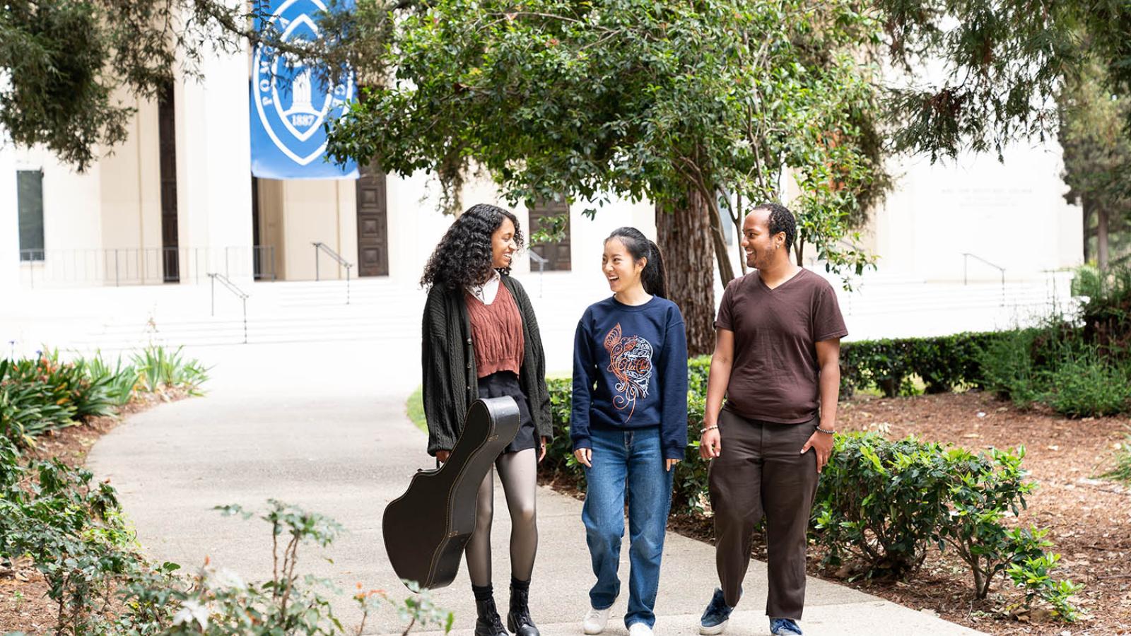 Three students walk in front of Big Bridges
