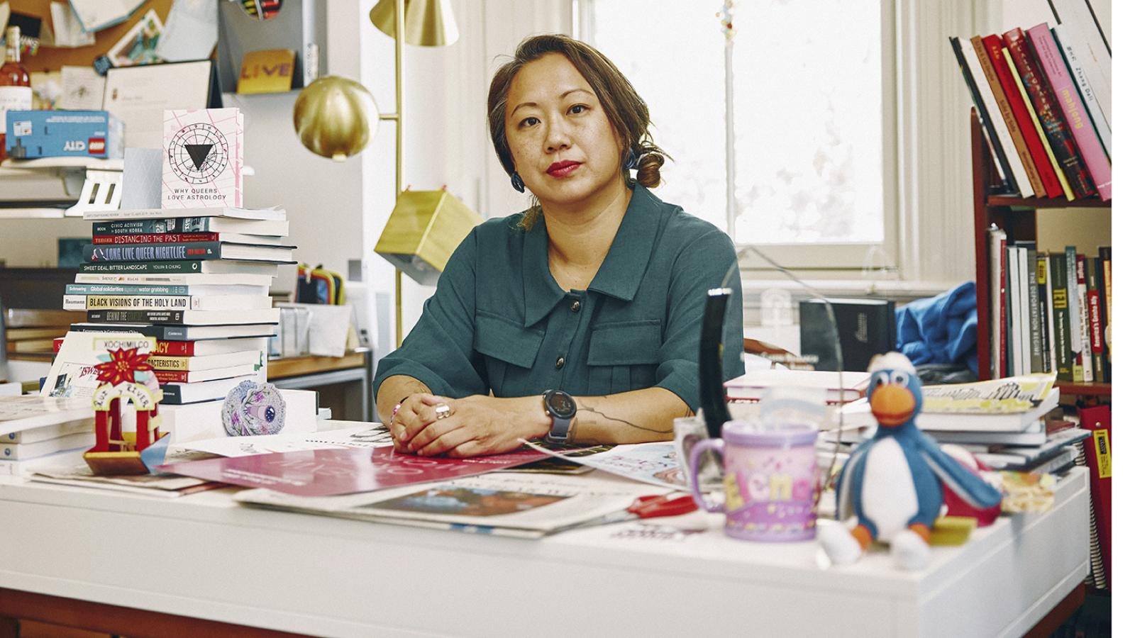 Elena Shih seated at her desk.