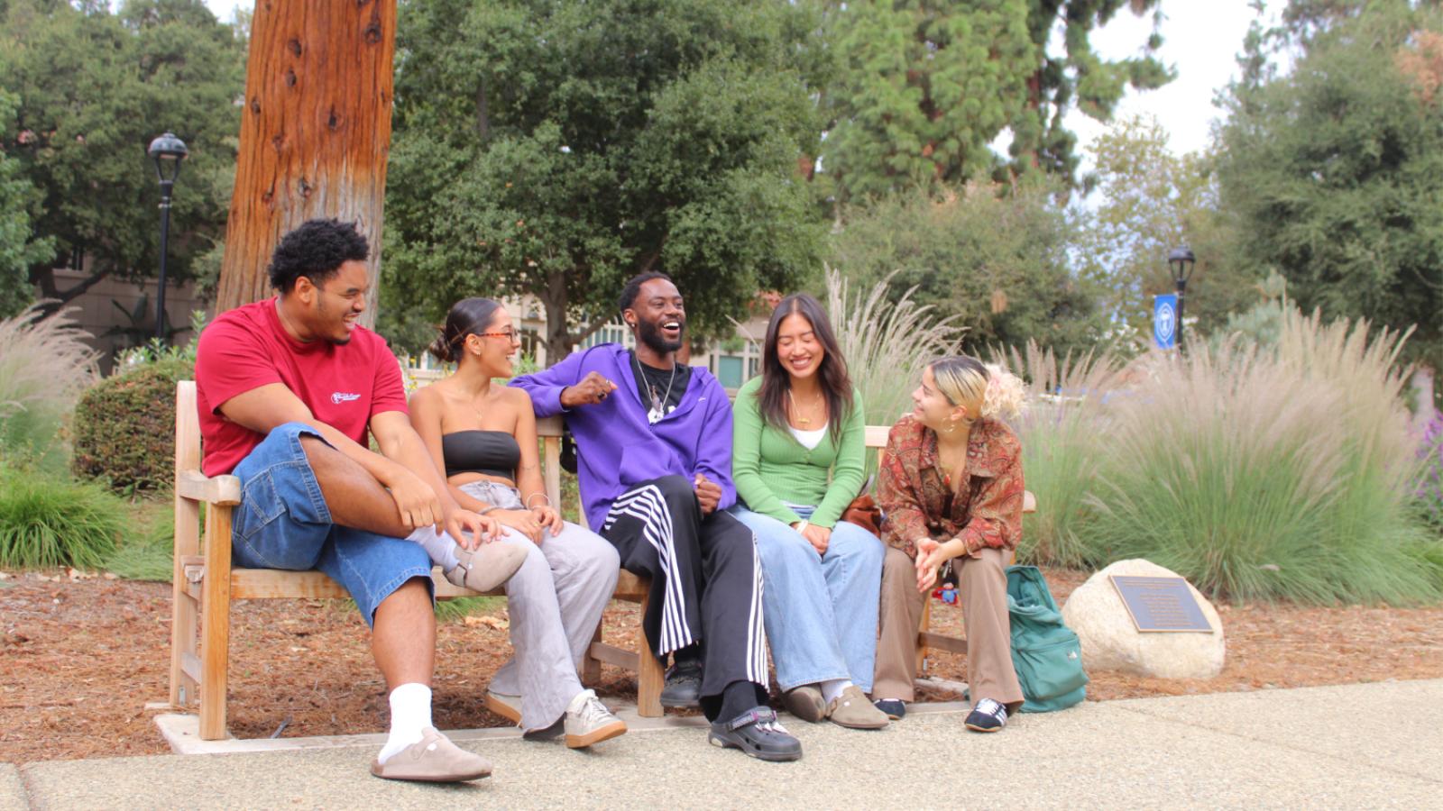 Students in Marston Quad sitting on a bench