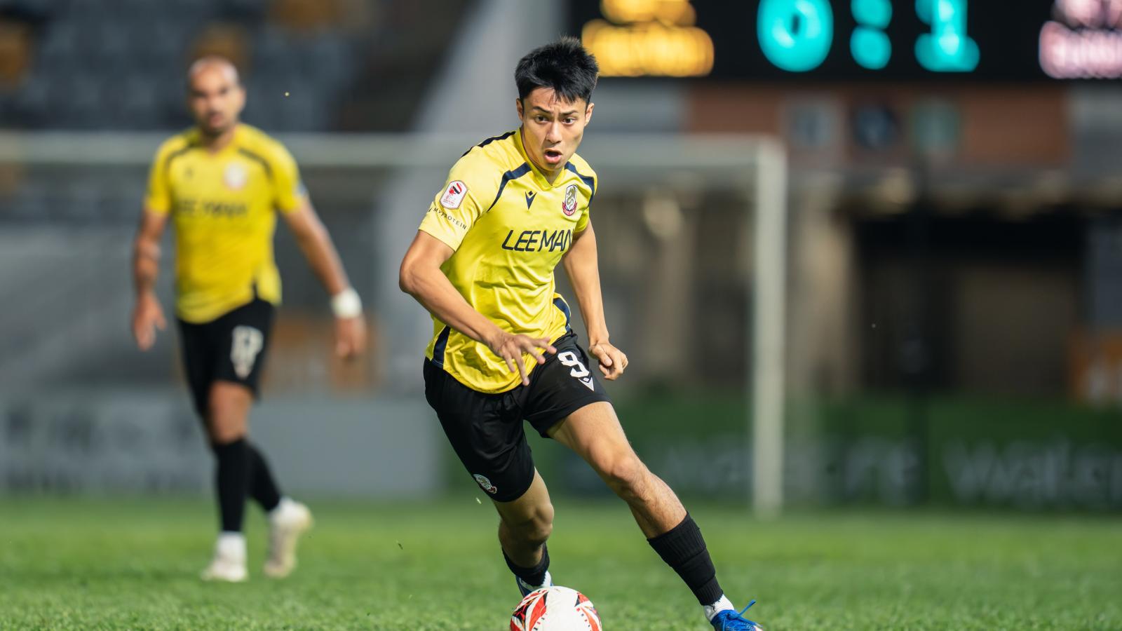 Kyle Lau dribbles a soccer ball
