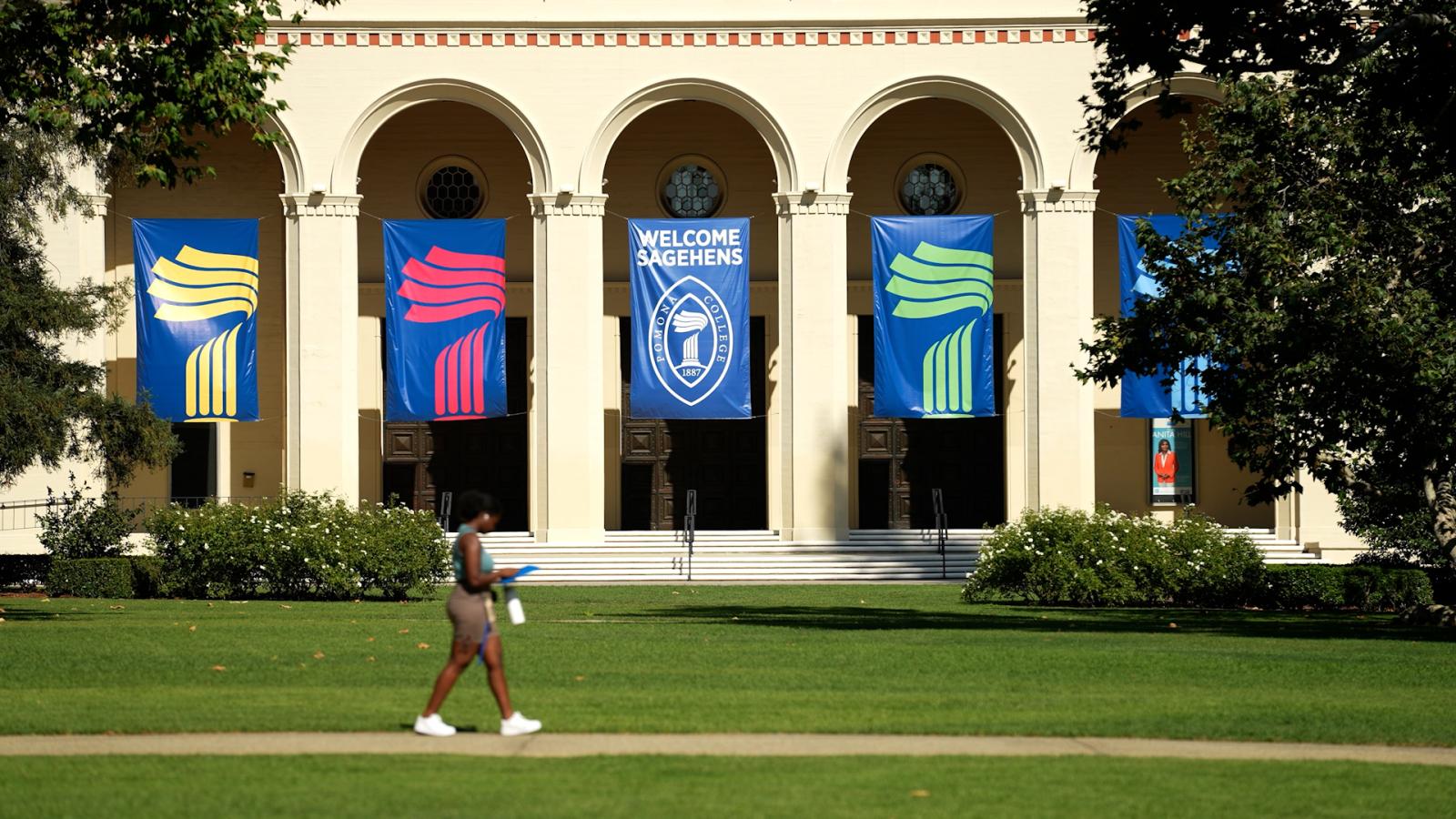 student walking in marston quad in front of banners