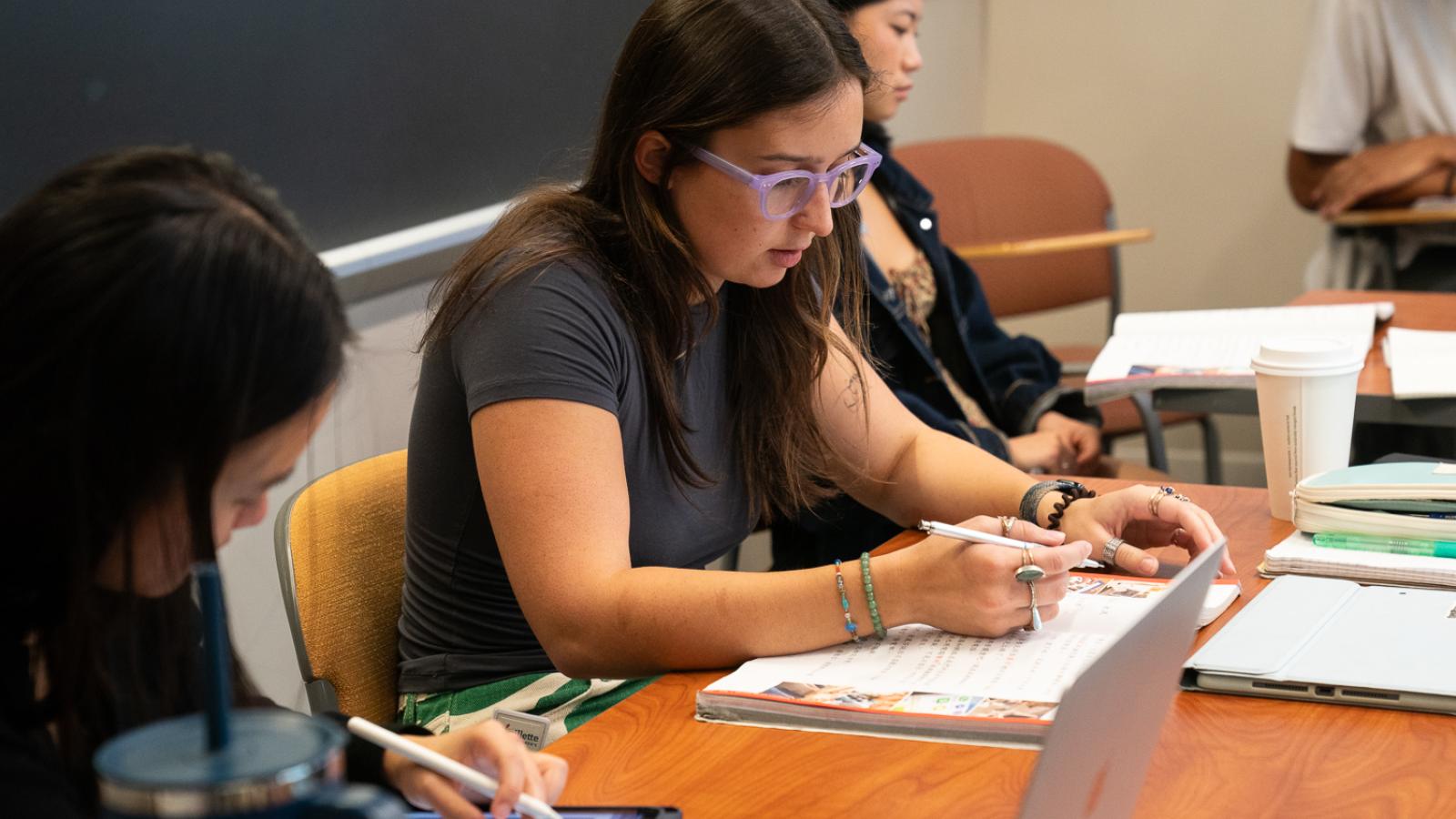 A student writes in a notebook