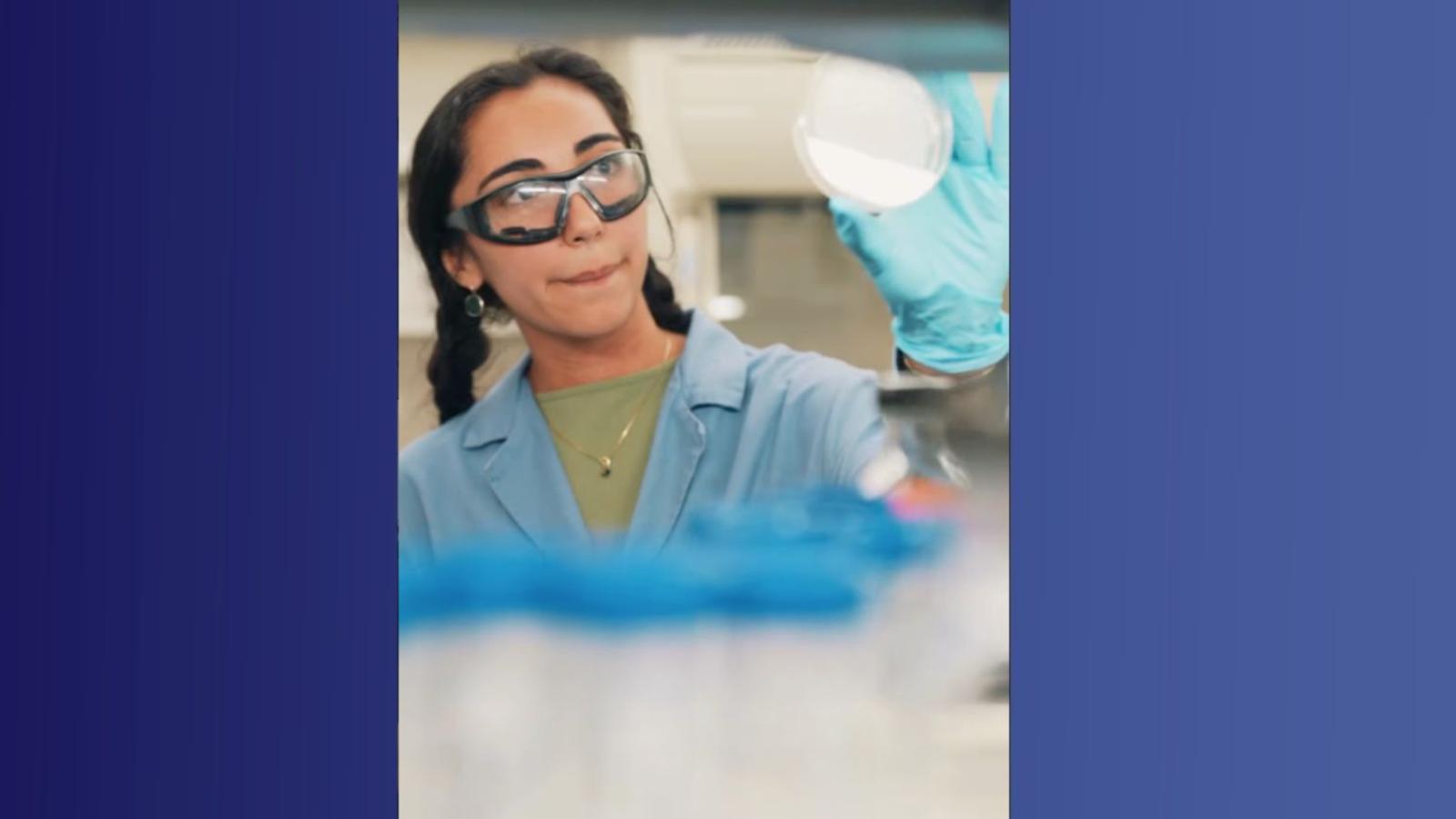 A student holds a piece of lab equipment