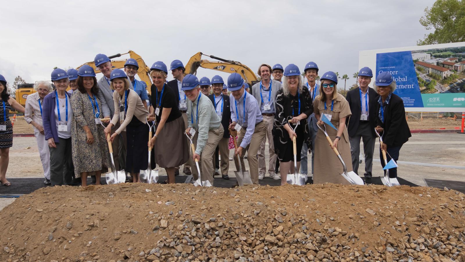 A group of people dig shovels into the ground