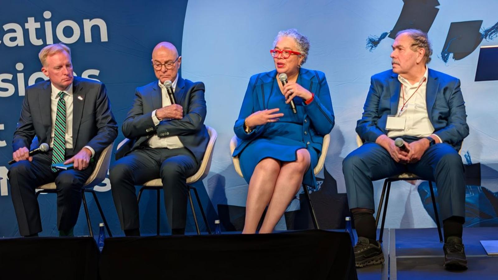 Four adults sitting on stage