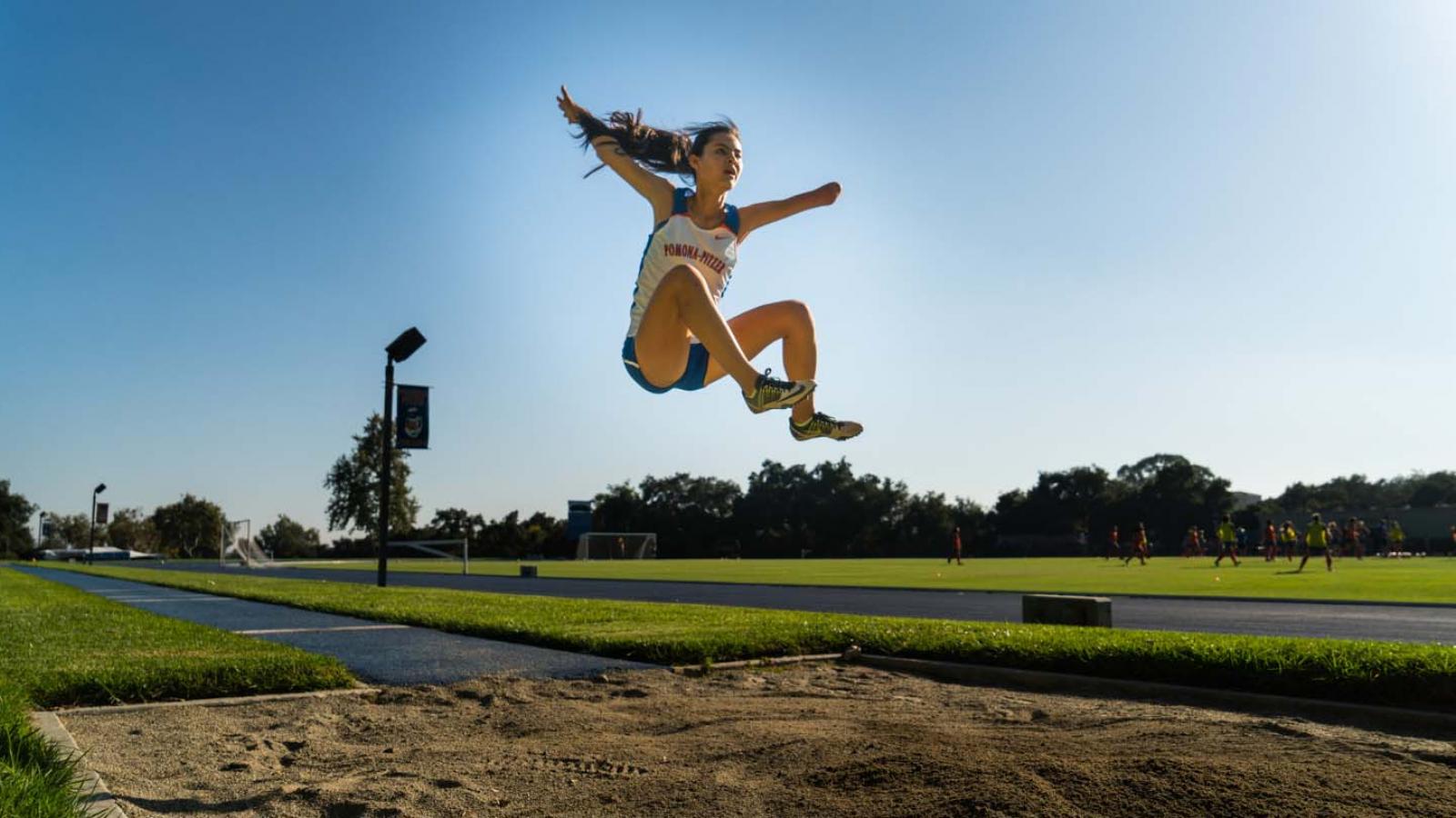 Amy Watt in the air doing a long jump