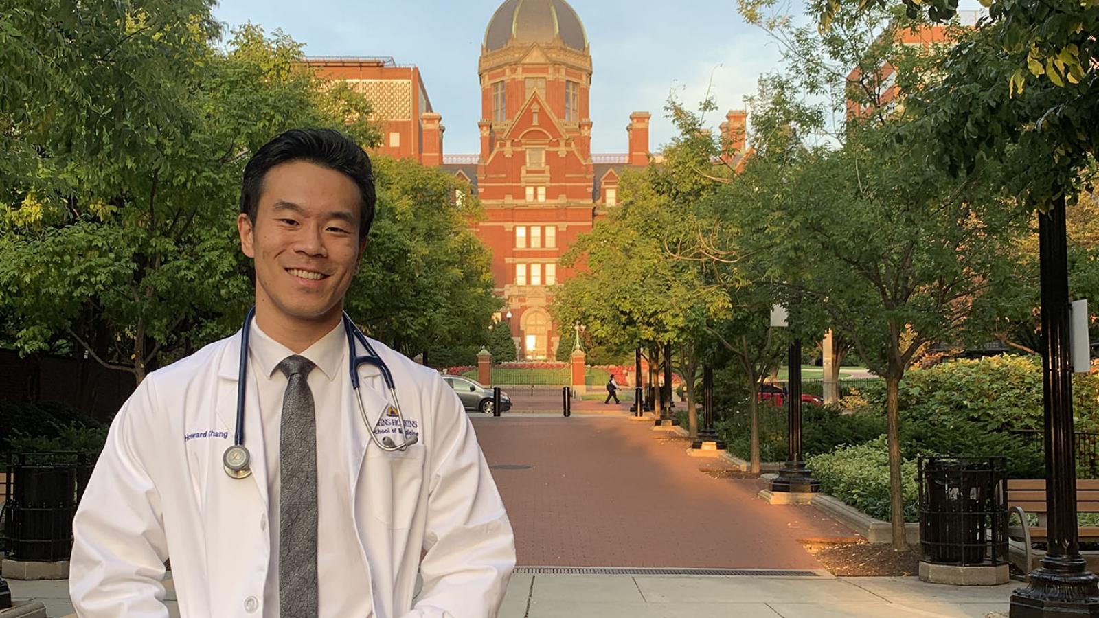 Howard Chang '14 in medical white coat at Johns Hopkins University