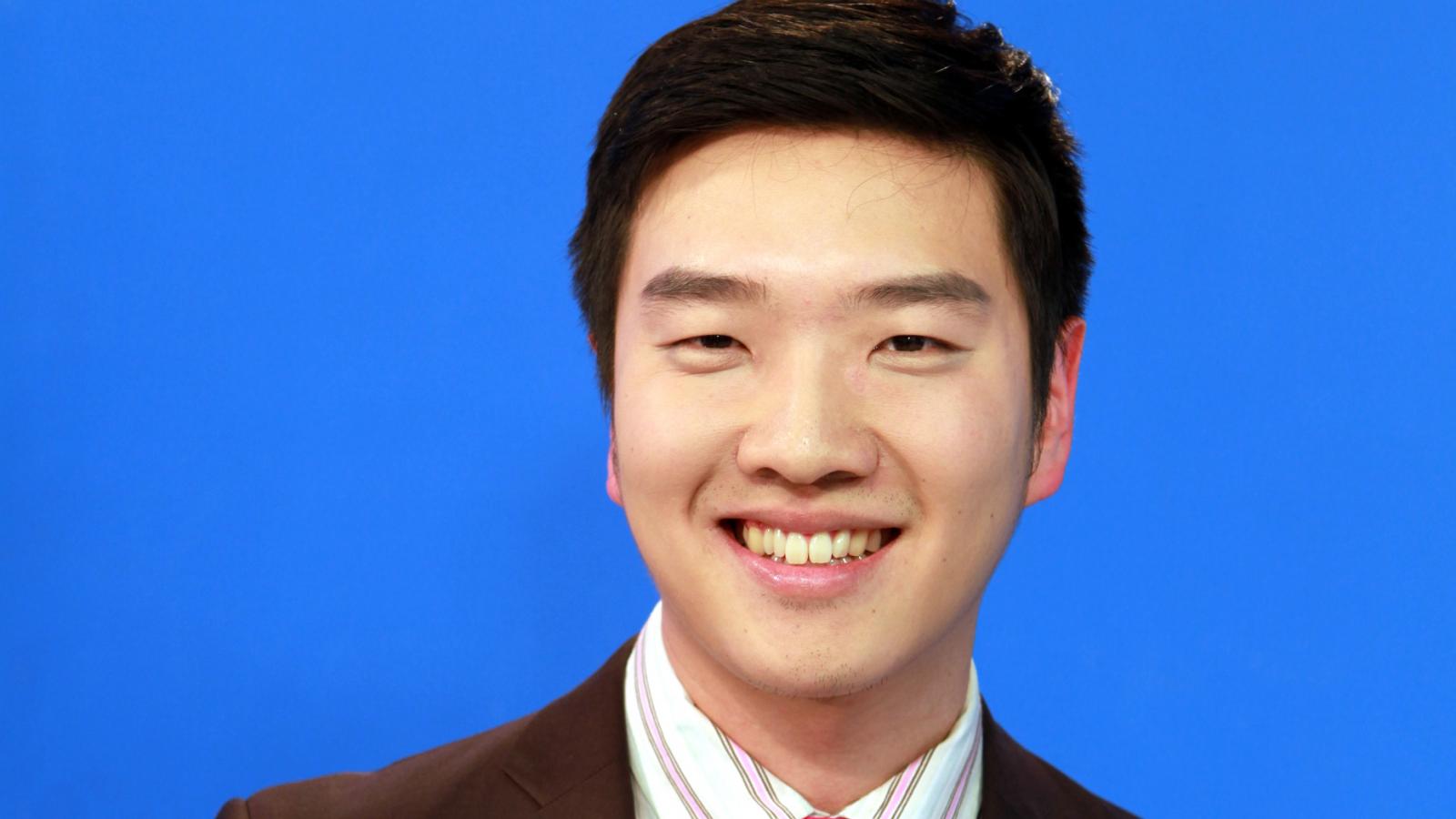Headshot of Daniel Shin against a blue background.
