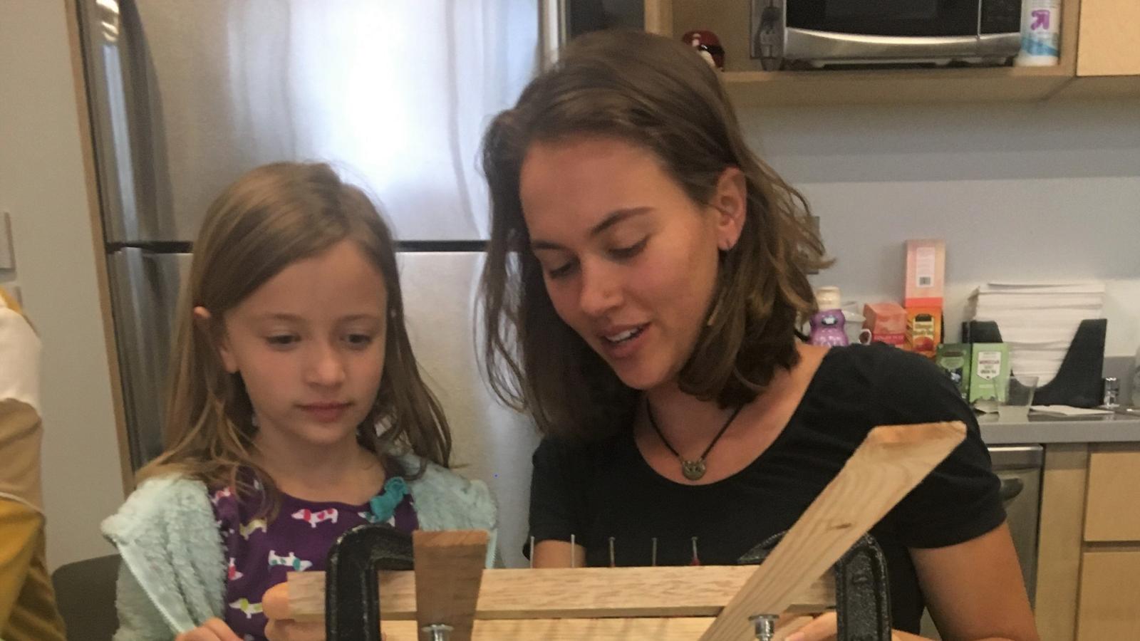 Sara and Avery hand weaving with a mini loom at Feminist Art Day
