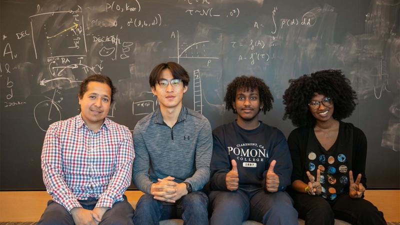 Professor Jorge Moreno and three students seated in front of chalkboard at the Flatiron Institute