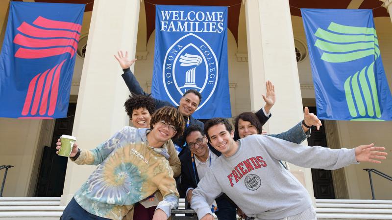 photo of a Pomona College family in front of Bridges Auditorium with a banner behind them that says welcome families