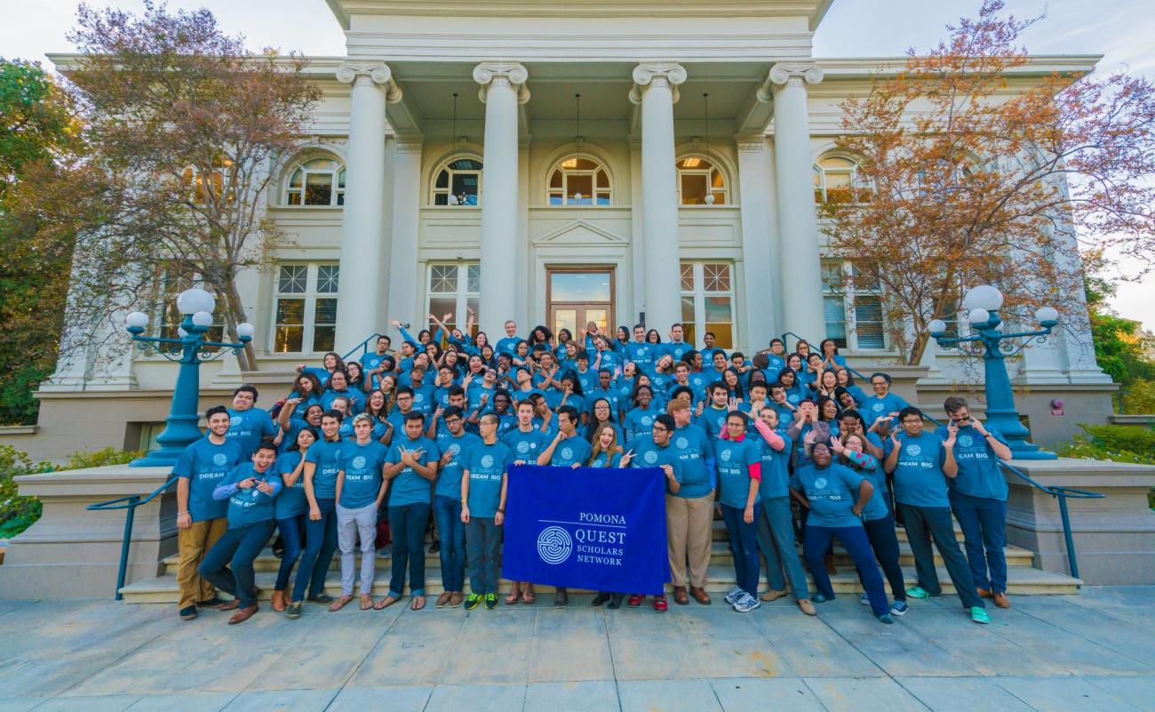 About 60 students with QuestBridge T-shirts making goofy gestures, standing in front of Carnegie Hall with Quest Scholars banner