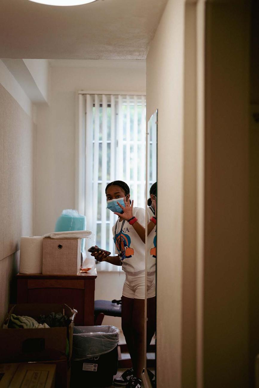 student waves from her res hall room