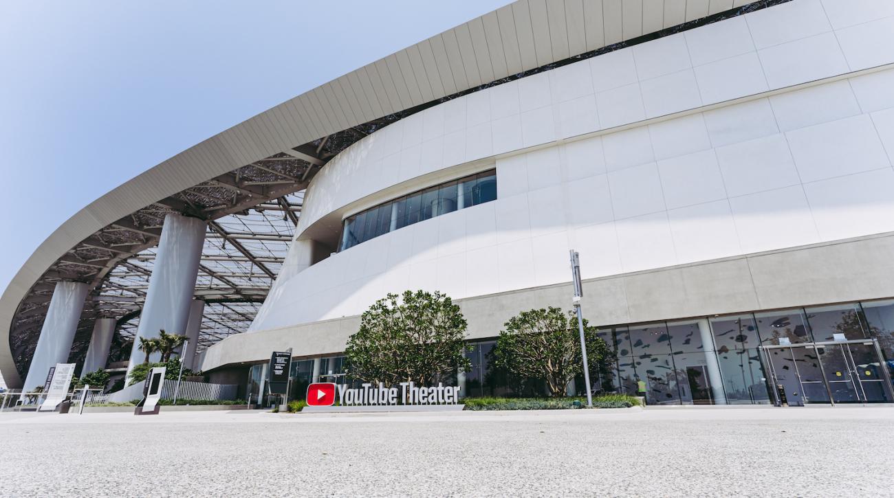 Exterior image of the entrance to YouTube Theater at SoFi Stadium with art visible through windows.