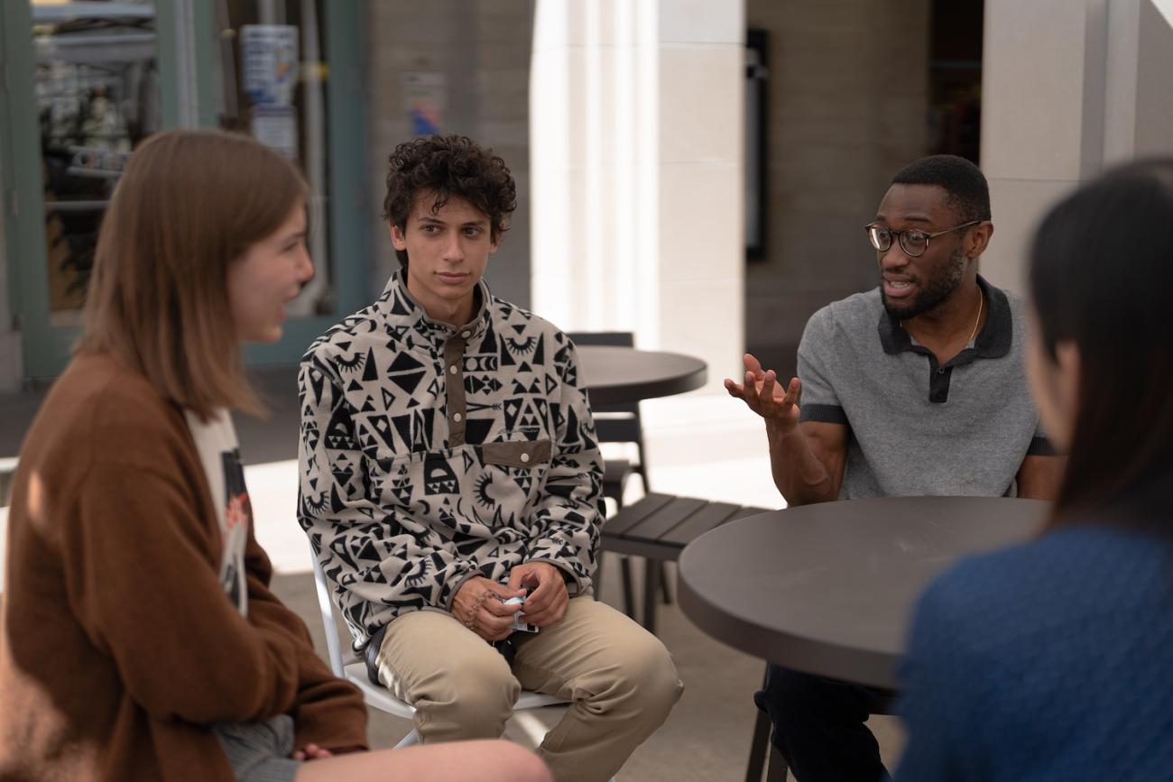 Musa Kamara '22, wearing glasses, leading discussion with group of speaking partners