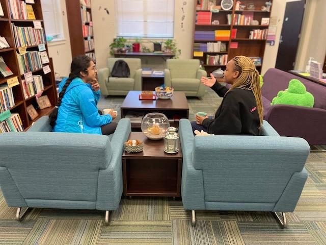 two students in a consultation, talking and smiling at each other