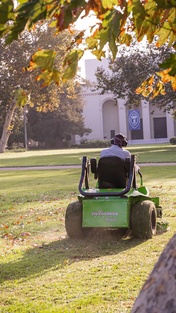 Mean Green electric lawnmower on grass in front of Bridges Auditorium