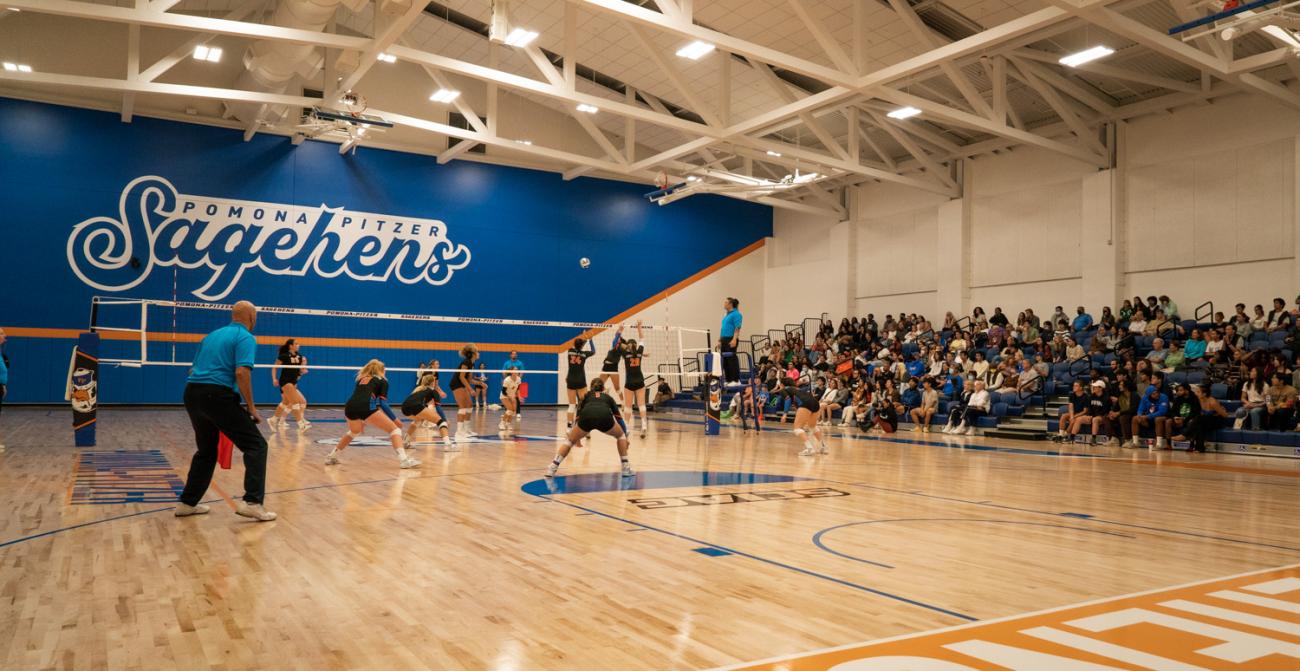 Volleyball action with logo and stands in background