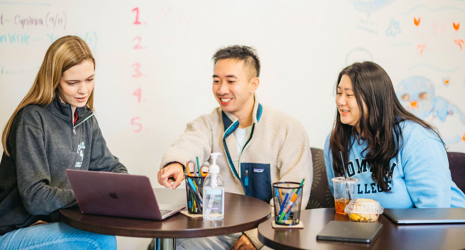 3 students sitting and looking at laptop