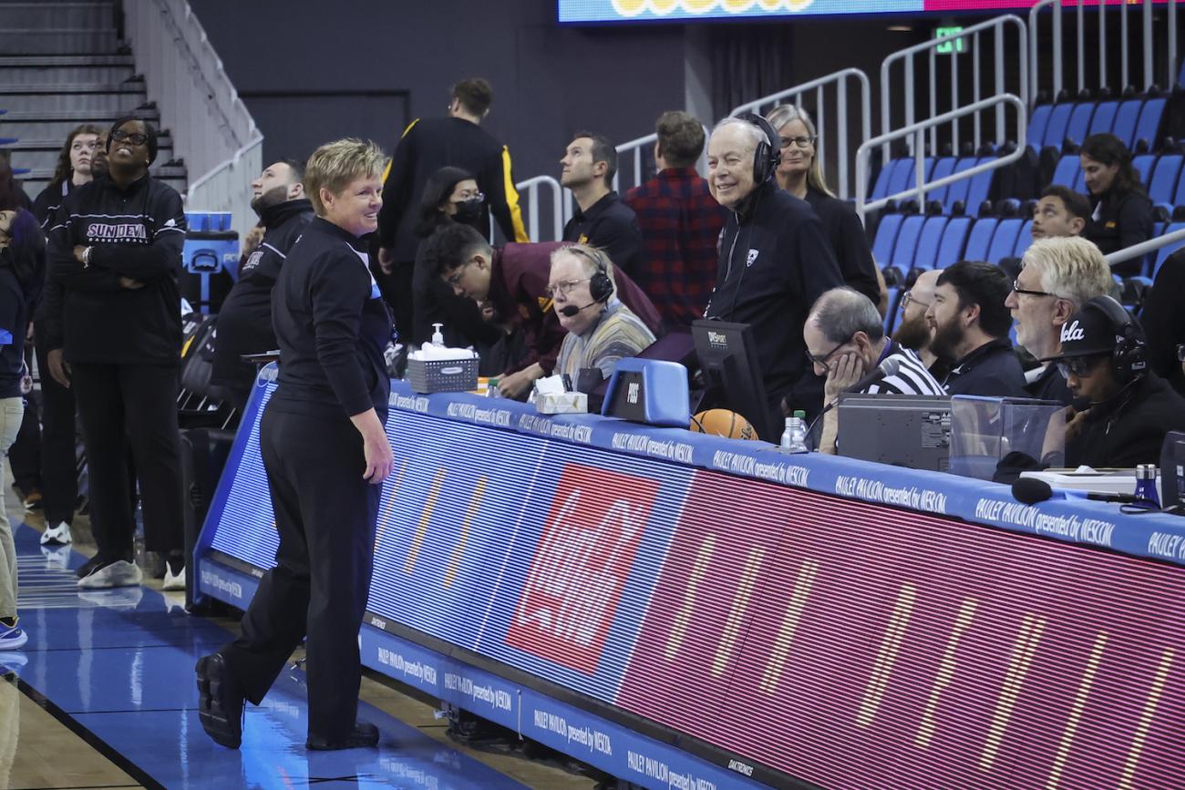 Referee Melissa Barlow '87 banters with officials at the scorer's table.