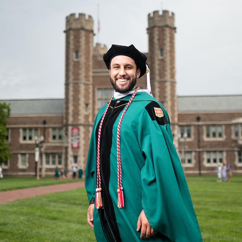 Cesar Mesa in graduation robe on campus in St. Louis