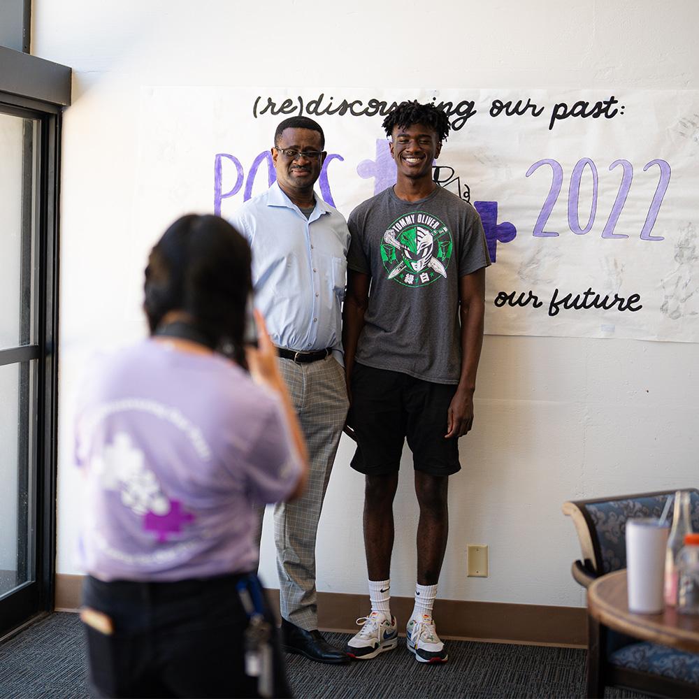 Father and son getting photo taken while checking in for the PAYS program