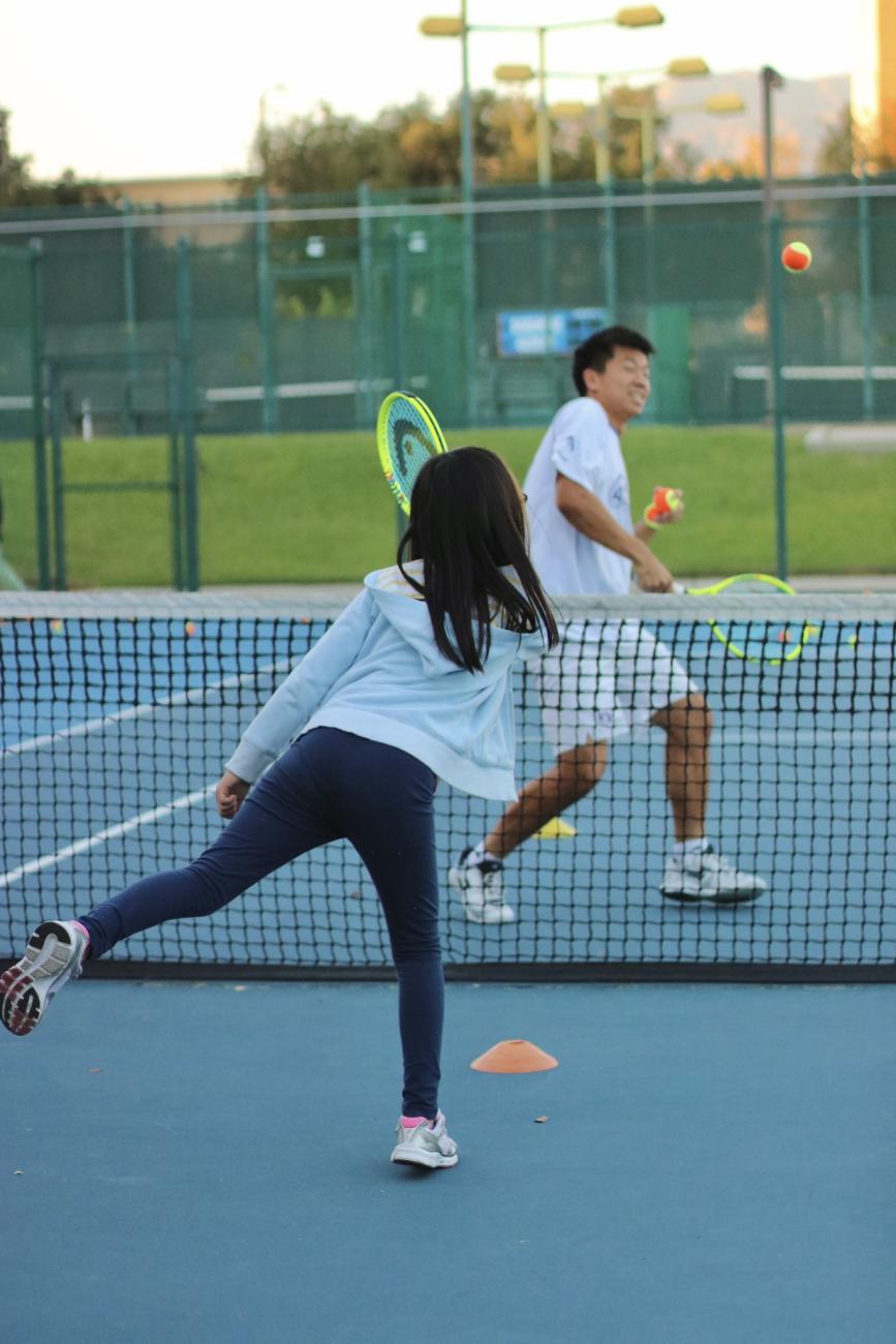 A child hitting a tennis ball during an ACEing Autism session at Pomona College.