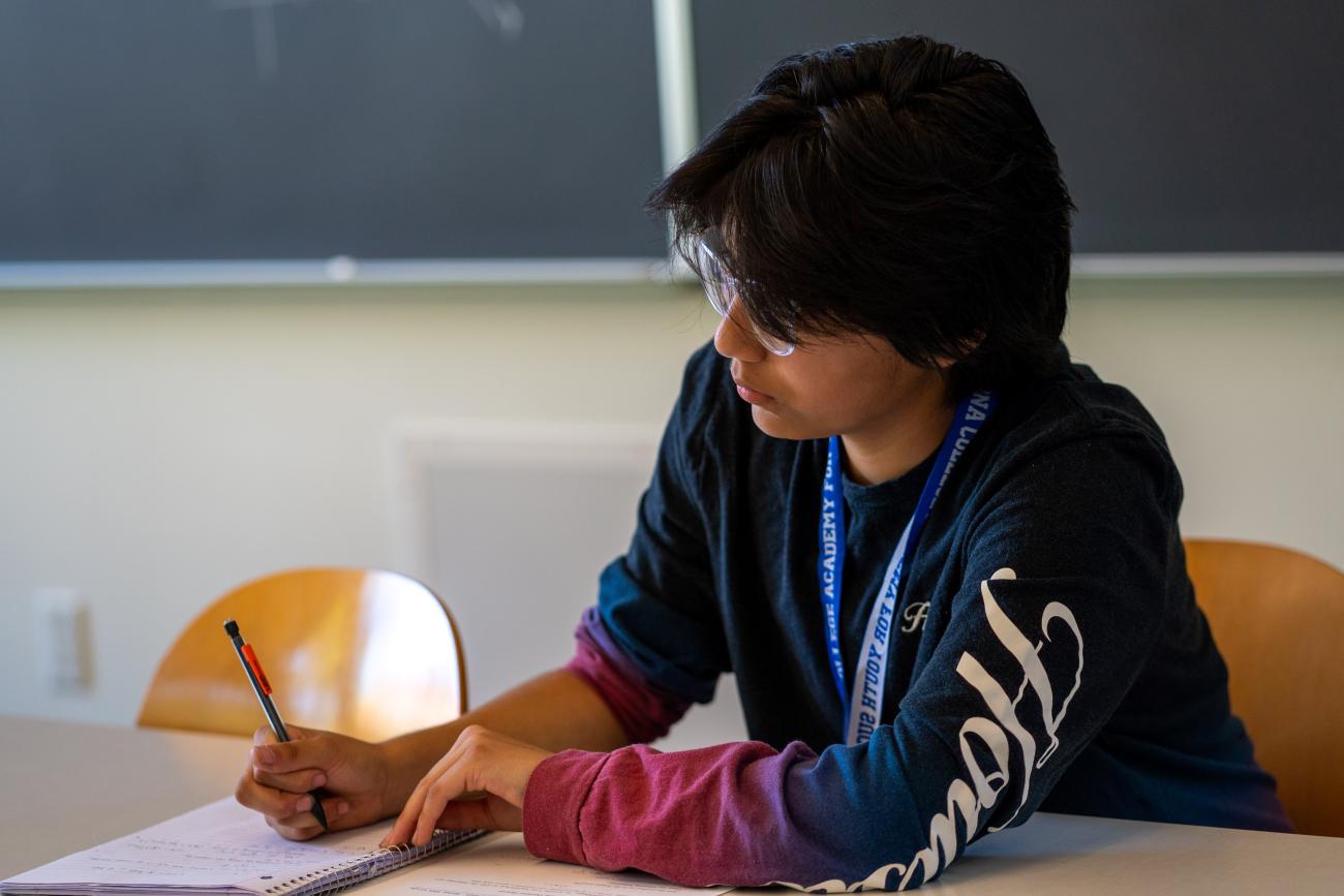 Current PAYS Scholar, Noah '26, writing notes during his math course.