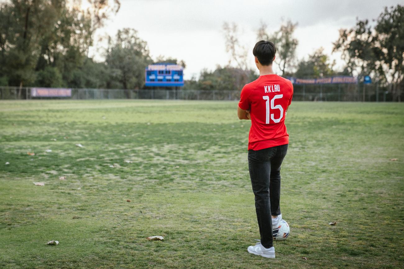 Kyle Lau stands with a ball at his feet