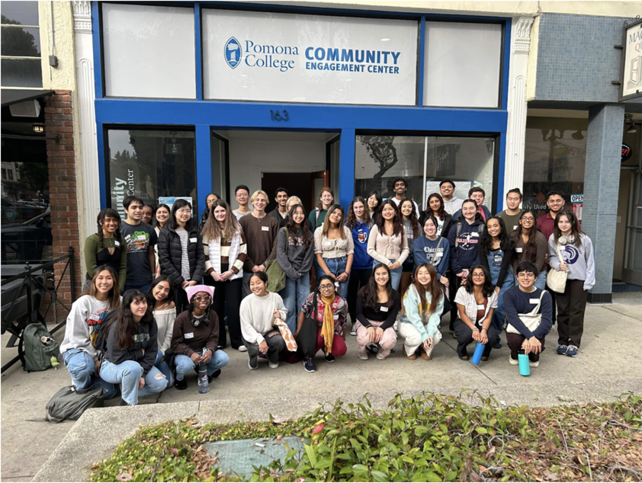 Group of students stand in front of community center building. 